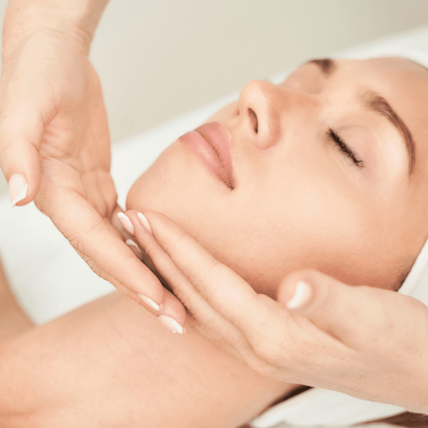 Spa facial treatment with woman receiving gentle chin massage.